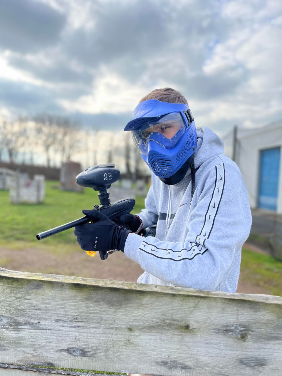 Une joueuse débutante vise avec son lanceur lors d'une partie de paintball